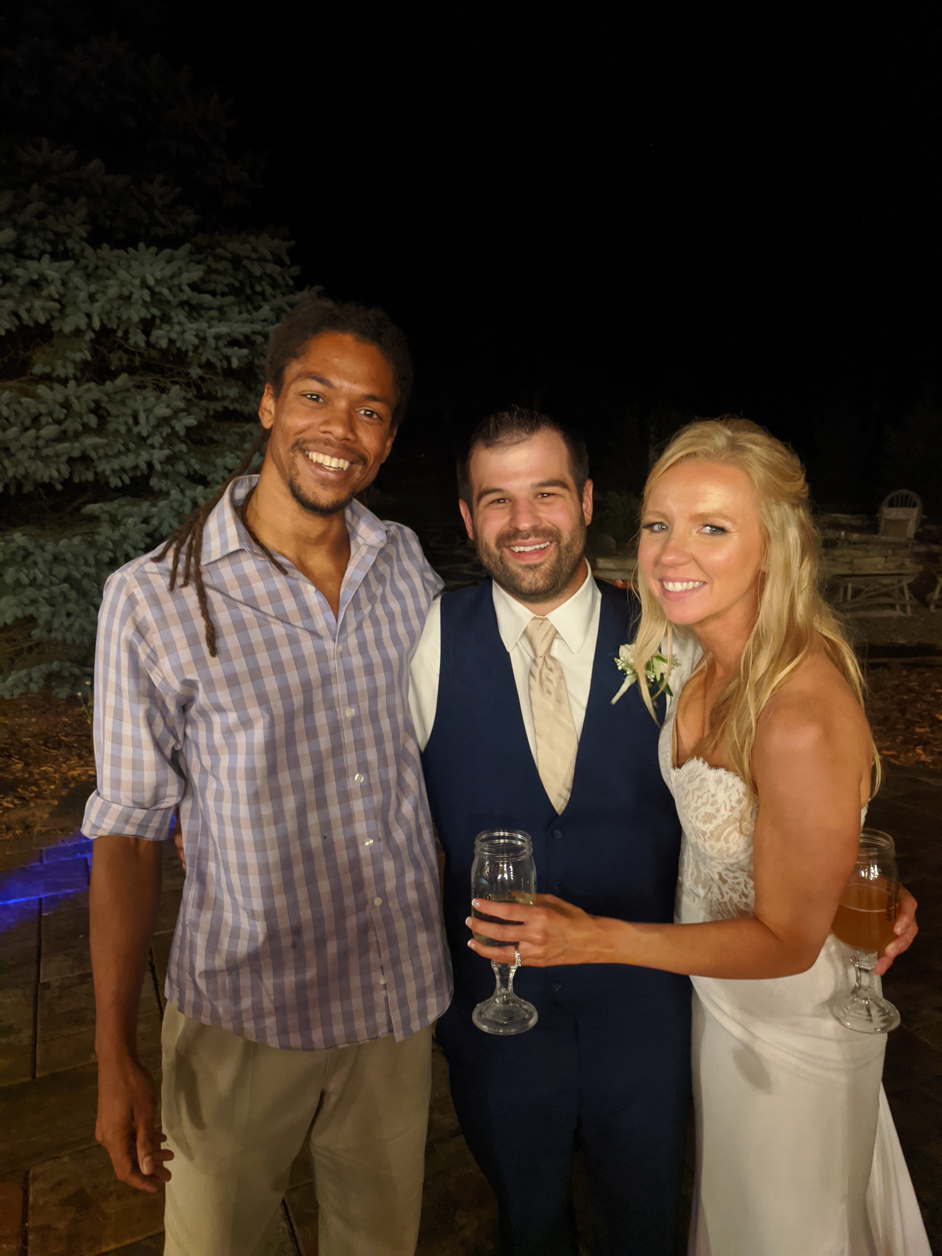 Nick May with wedding couple outdoors at night