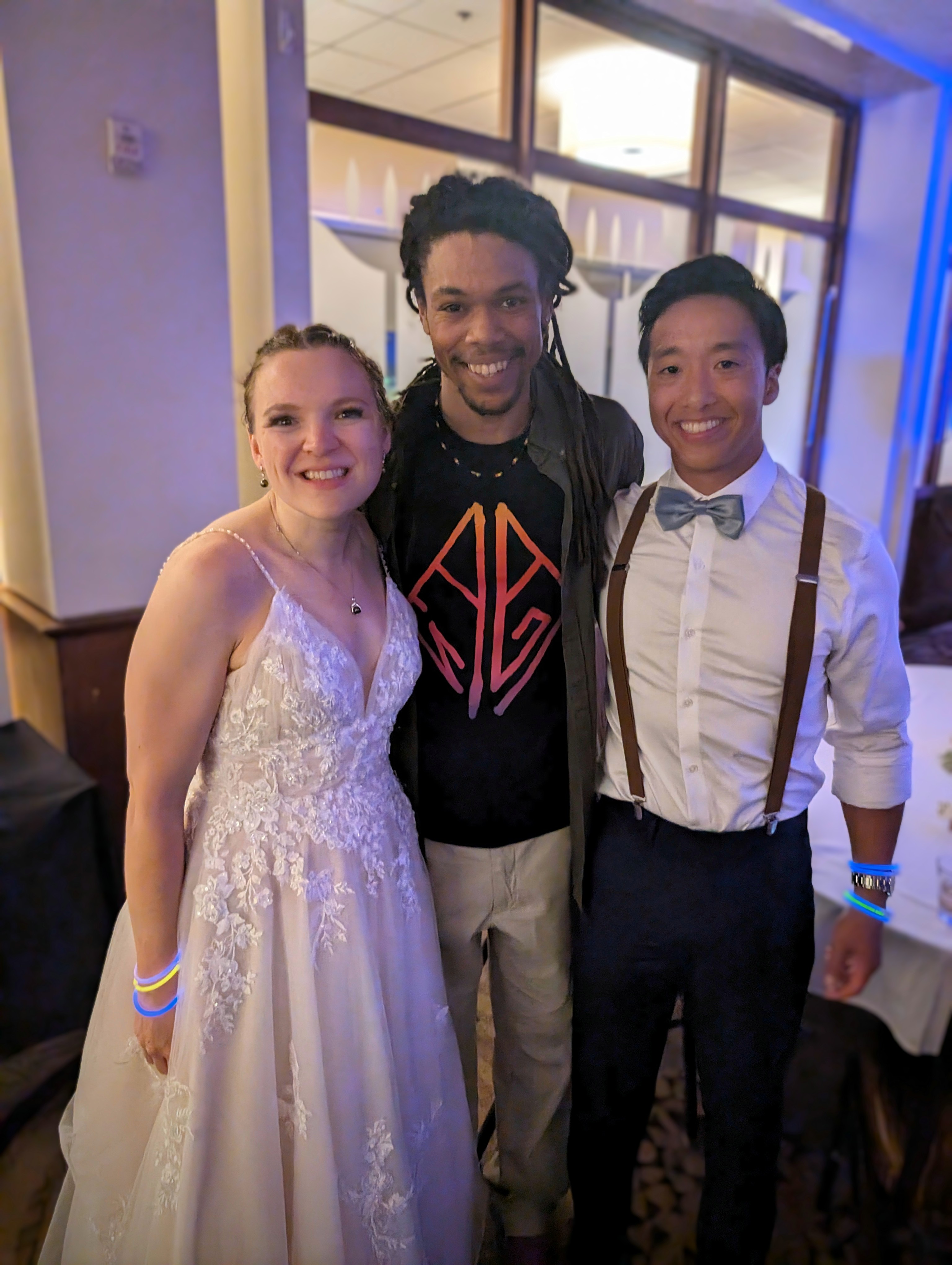 Nick May with wedding couple at reception