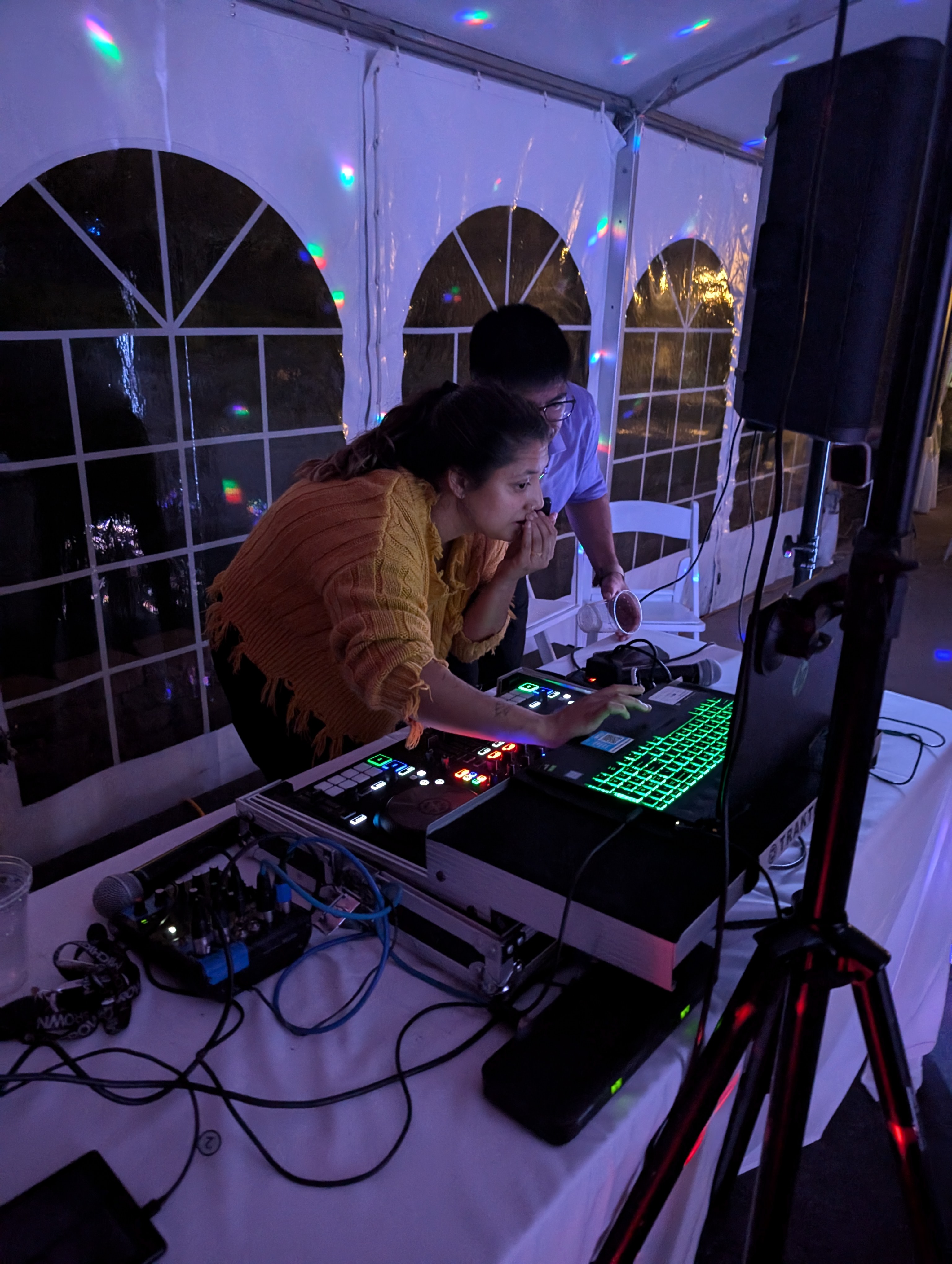 Nick May DJ mixer setup with colorful lights at event